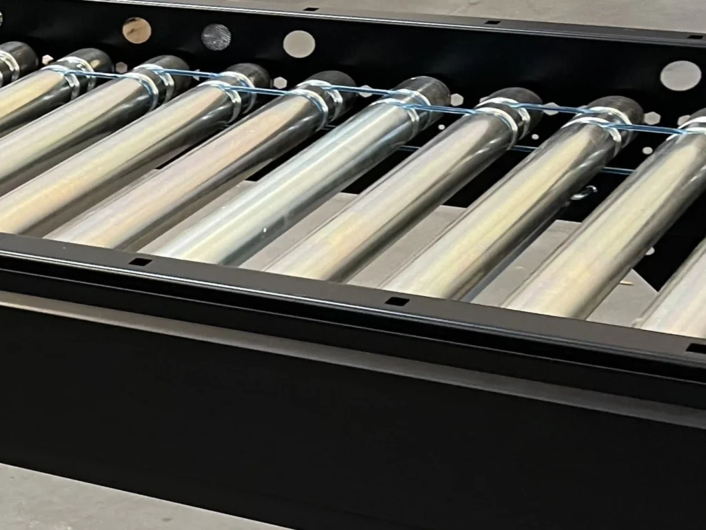 A conveyor bed with two grooved rollers and alternating o-bands in the grooves. The o-bands are also staggered which connects the rollers to each other.