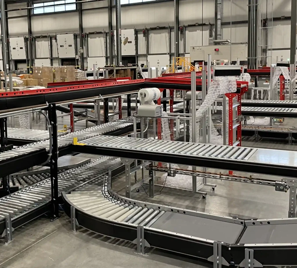 A three level conveyor system with red and black rails that contain merges, ramps and diverts.