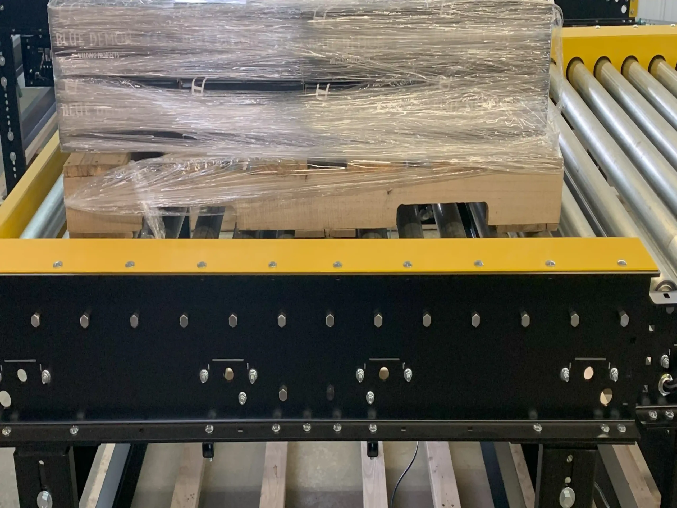 Three pallets stacked on top a pallet conveyor.